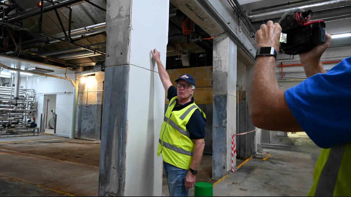 Norco General Manager of Operations Adrian Kings shows the February 2022 flood height inside the South Lismore factory. Picture: Cathy Adams